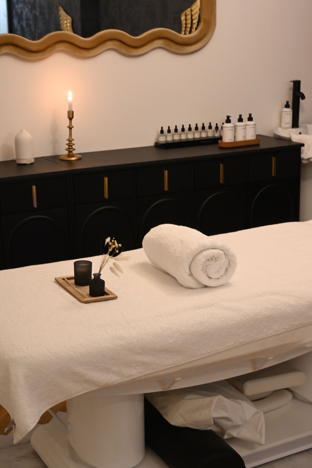 A calm, tidy treatment space with soft candlelight and folded linens.